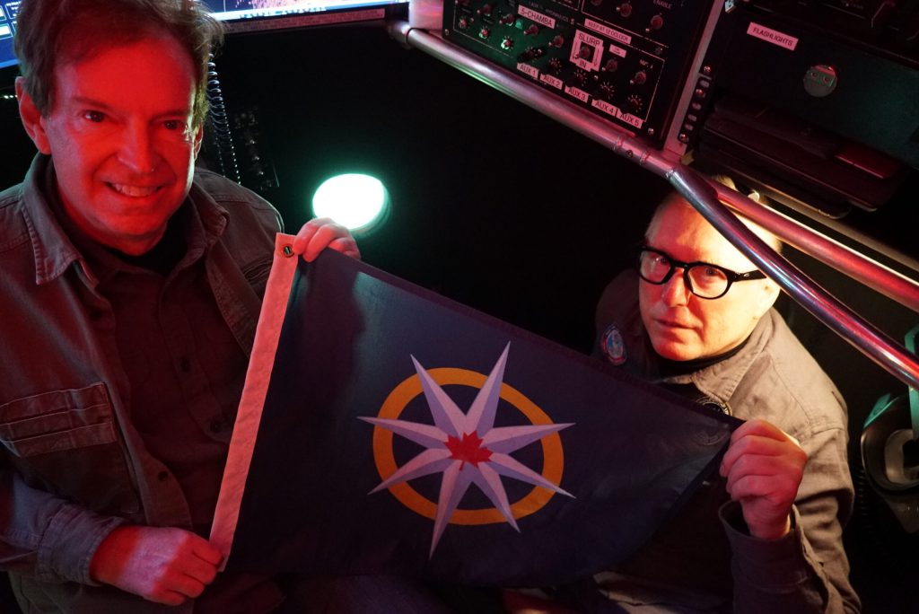 Før vi dro opp, ble ekspedisjonens flagg og bannere fotografert 166 meter under overflaten. Her er banneret til Royal Canadian Geographical Society (BE).