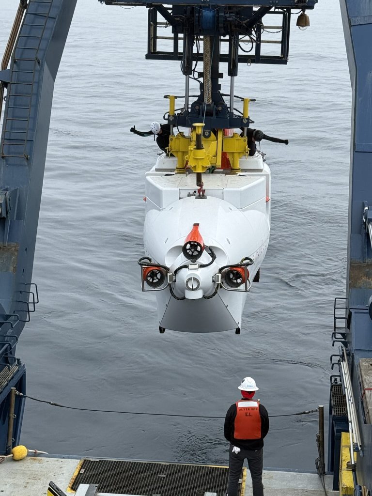 Svømmerne signaliserer at Alvin har kommet trygt klar av akterenden på Atlantis (JC).